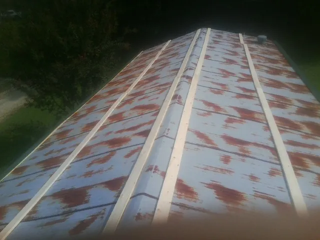 Rusted metal roof panels with new wood purlins before replacement — Storm Damage Roof Repair in Barnard by Roofing Brothers