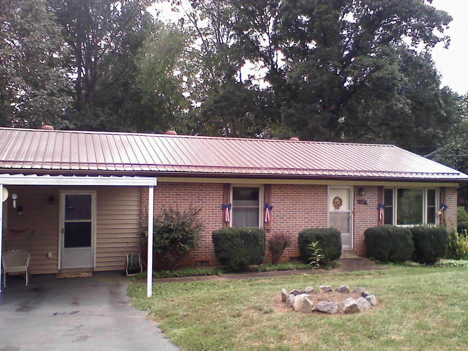 Bronze metal roof and carport on a brick ranch home — Roof Repair work by our crew in Barnard